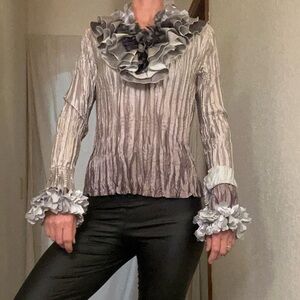 Silver frilly blouse. Bird? Mushroom? Fancy clown?